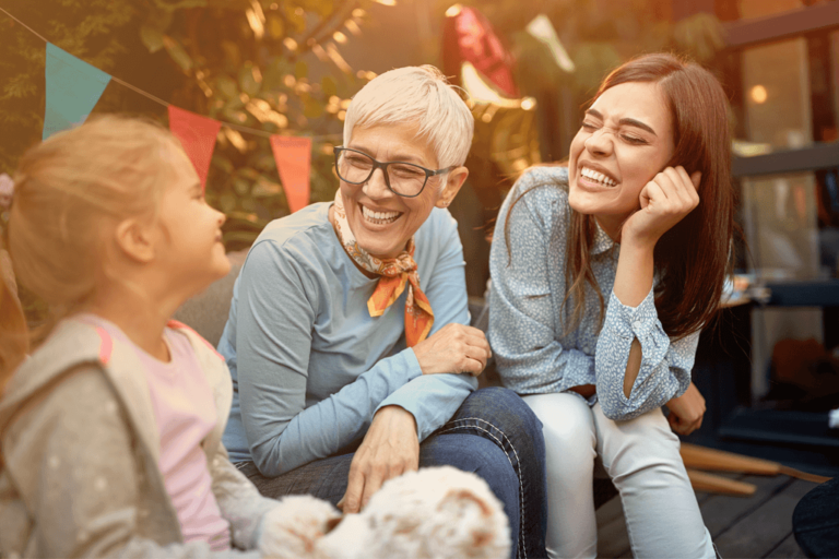 Three generations of women smiling at each other