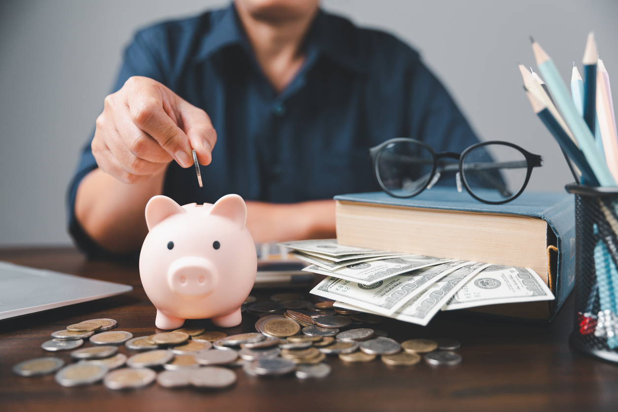 Man at desk with money he took from piggy bank