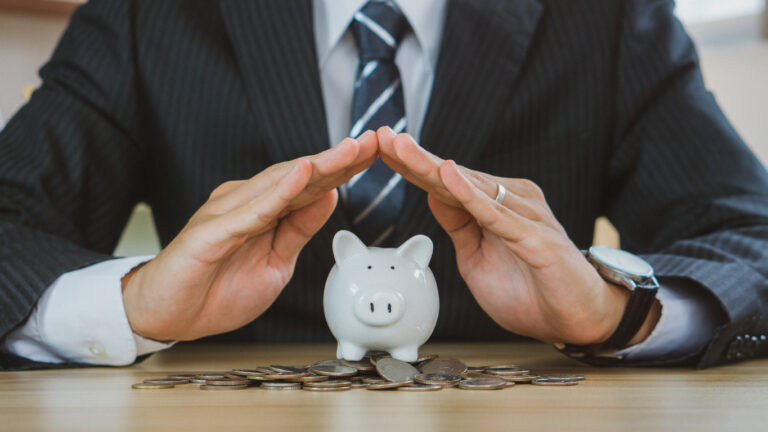 man protecting the piggybank in hand