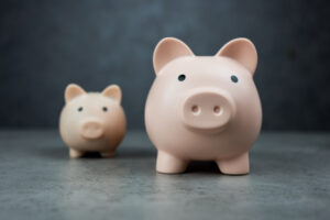 Big piggy banks with a blur of small piggy banks behind.